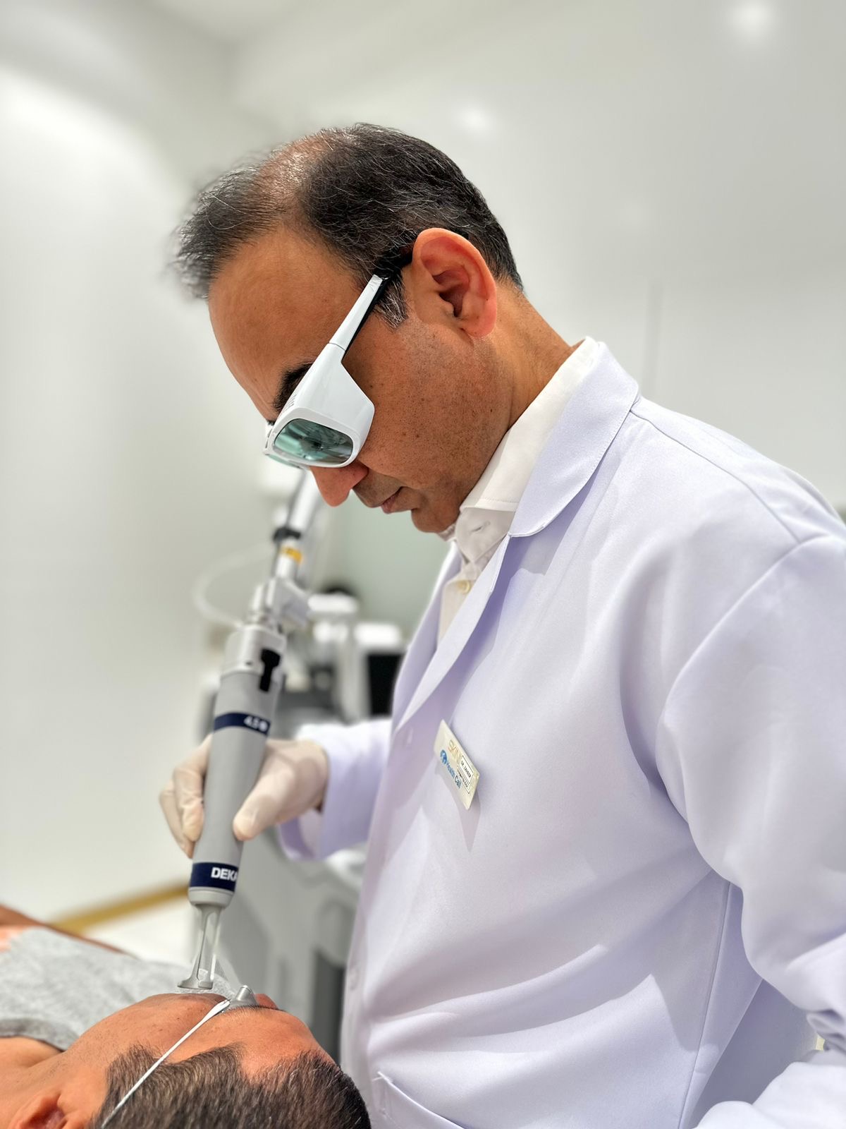 Dr. Zaheer Abbas performing a procedure with protective eyewear